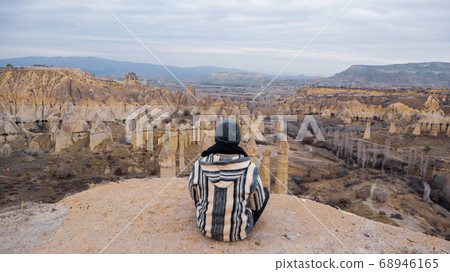 Man watching the volcanic landscape at the valley of love in Goreme, Cappadocia 68946165
