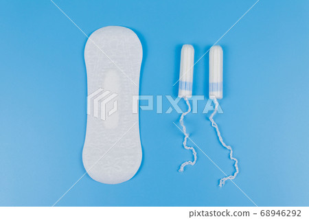 Sanitary pad and tampons on blue background Sanitary pad and tampons on blue background 68946292