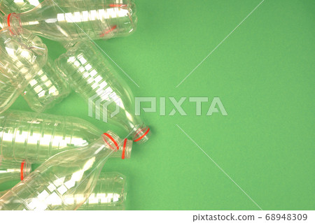 Empty plastic PET bottles on a green background. 68948309