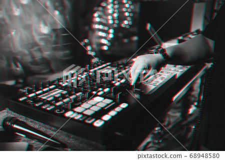 male DJ mixes electronic music on a professional music controller male DJ mixes electronic music on a professional music controller 68948580