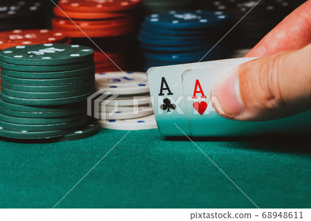 player reveals one pair of aces in poker against the background of playing chips on the green table player reveals one pair of aces in poker against the background of playing chips on the green table 68948611