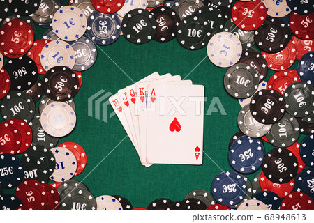 Royal flush on the background of gaming chips on the green table in the casino Royal flush on the background of gaming chips on the green table in the casino 68948613