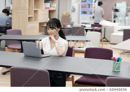A woman working on a computer in a coworking space 68949836