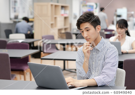 Women and men working on computers in the coworking space 68949840