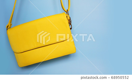 Yellow fashion female woman purse handbag on blue 68950552