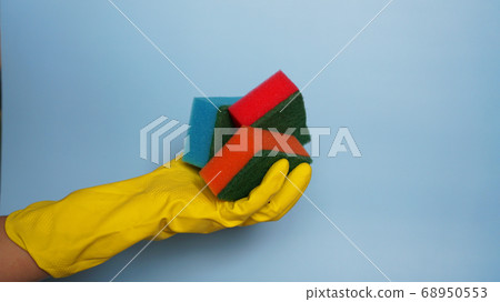 Hand in glove holding few washing sponges - amount of housework concept 68950553