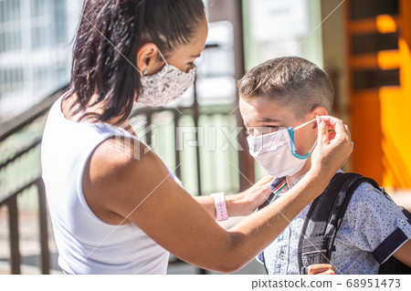 A mother and herson use a protective mask when A mother and herson use a protective mask when 68951473