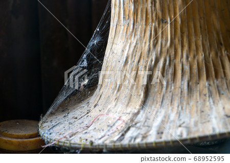 Spider web on a straw hat, close up. Old things in 68952595