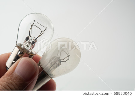 hand holding old burnt Car tail lamp with smoked inside and new one hand holding old burnt Car tail lamp with smoked inside and new one 68953040