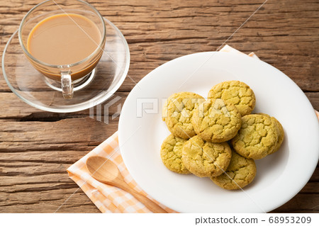 Cookie in white plate with cup of coffee on table 68953209