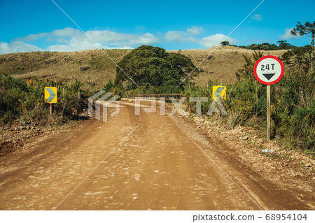 Dirt road on rural lowlands with dry hills Dirt road on rural lowlands with dry hills 68954104
