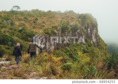 People on the edge of rocky cliff and mist People on the edge of rocky cliff and mist 68954253