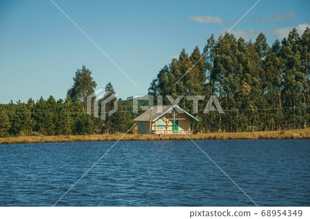 Wooden chalet facing a blue water lake Wooden chalet facing a blue water lake 68954349
