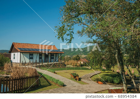 House with garden amid rural landscape 68954384