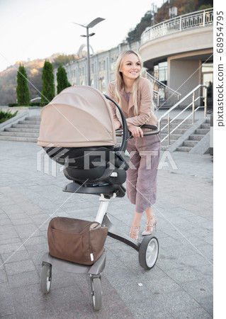 Beautiful mother with a pram Beautiful mother with a pram 68954795
