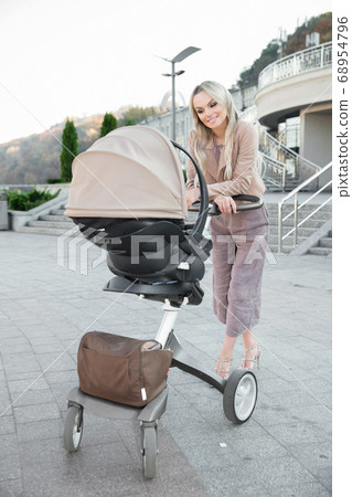 Cute mother with a pram Cute mother with a pram 68954796
