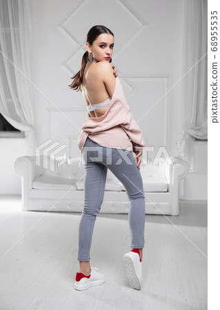 Cute brunette dressed in pink pullover Cute brunette dressed in pink pullover 68955535