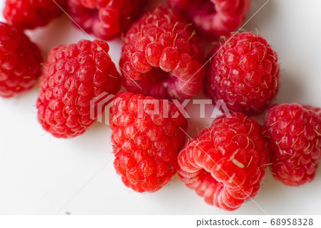 A picture of a few raspberries lies on a white A picture of a few raspberries lies on a white 68958328