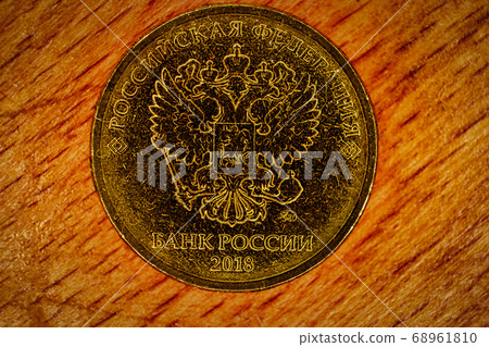 Russian coin of golden alloy. Revers with seal of Bank of Russia depicting twin headed eagle with heraldic signs. Words in russian - Russian Federation. Bank of Russia, 2018 Russian coin of golden alloy. Revers with seal of Bank of Russia depicting twin headed eagle with heraldic signs. Words in russian - Russian Federation. Bank of Russia, 2018 68961810