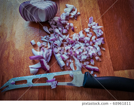 Cutted in pieces shallot onion with knife on foreground. Cutted in pieces shallot onion with knife on foreground. 68961811