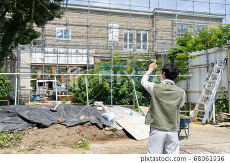 Male worker using a smartphone at a construction site Male worker using a smartphone at a construction site 68961936