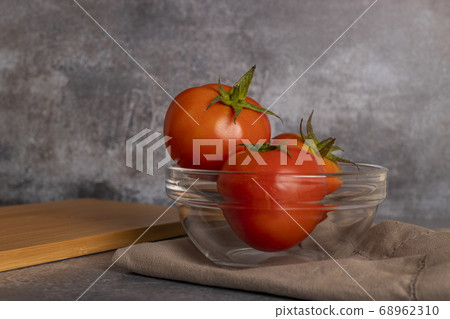 Tomatoes in salad inside a white bowl on grayish Tomatoes in salad inside a white bowl on grayish 68962310