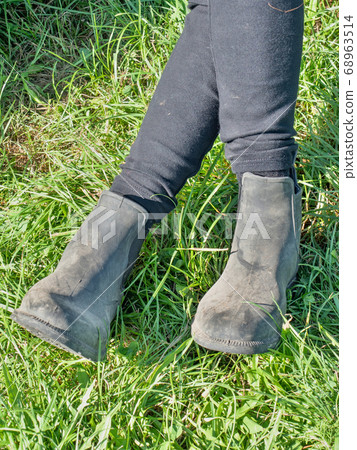 Woman horse rider sit with crossed legs in paddock Woman horse rider sit with crossed legs in paddock 68963514