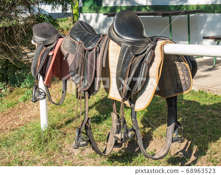 Classic leather horse saddles on mooring beam 68963523