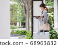 A woman waiting for a bus at the bus stop 68963832