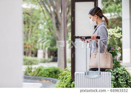 A woman waiting for a bus at the bus stop A woman waiting for a bus at the bus stop 68963832