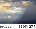 A ray of sun shines from behind the clouds 68964275