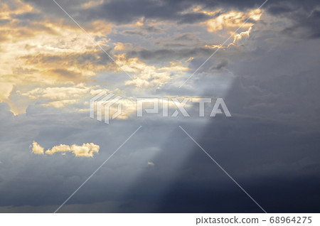A ray of sun shines from behind the clouds 68964275