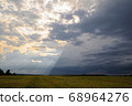 A ray of sun shines from behind the clouds 68964276