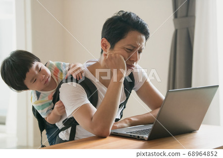 Image of father working at home while caring for his child 68964852