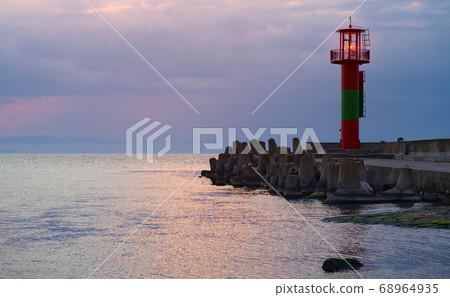 Lighthouse protected by concrete breakwater 68964935