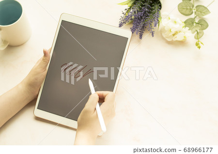 A woman's hand with a tablet 68966177