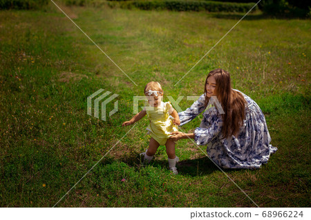 happy mother plays with her little daughter at the happy mother plays with her little daughter at the 68966224