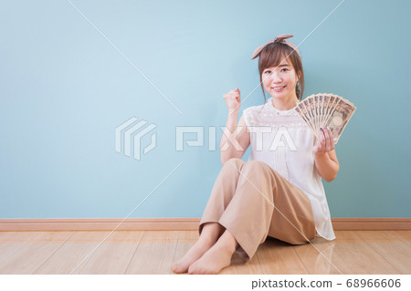 有膽量的微笑的婦女擺在拿著金錢 有膽量的微笑的婦女擺在拿著金錢 68966606