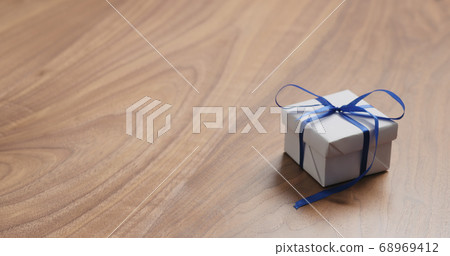 white paper gift box with blue ribbon on walnut table with copy space white paper gift box with blue ribbon on walnut table with copy space 68969412