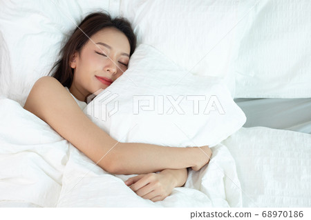 Asian women sleeping and sweet dream on white bed in bedroom Asian women sleeping and sweet dream on white bed in bedroom 68970186