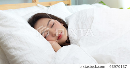Asian women sleeping and sweet dream on white bed in bedroom Asian women sleeping and sweet dream on white bed in bedroom 68970187