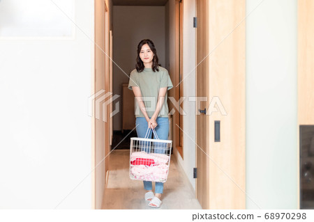 年輕的家庭主婦,在家裡洗衣服 年輕的家庭主婦,在家裡洗衣服 68970298