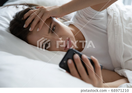 Close up unhappy stressed woman using phone, reading bad news Close up unhappy stressed woman using phone, reading bad news 68971210