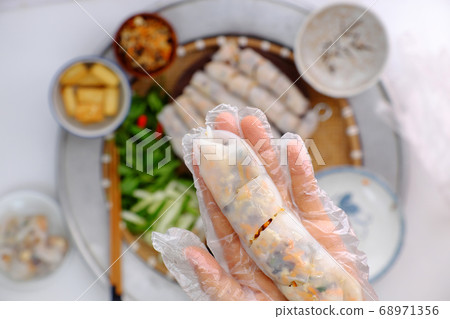 Vietnamese woman hand prepare breakfast, homemade vegan rice noodles roll from rice batter, delicious vegetarian stuffed dish 68971356