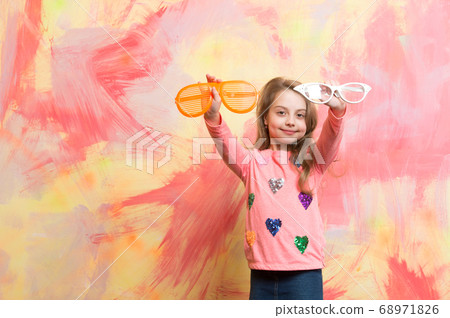 Girl smiling with two funny sunglasses Girl smiling with two funny sunglasses 68971826