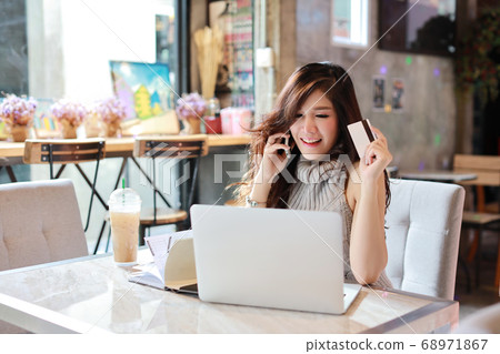 asian woman shopping and online payment on tablet and computer while show credit card in restaurant asian woman shopping and online payment on tablet and computer while show credit card in restaurant 68971867