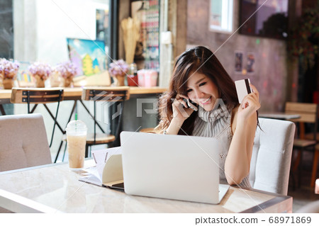 asian woman shopping and online payment on tablet and computer while show credit card in restaurant asian woman shopping and online payment on tablet and computer while show credit card in restaurant 68971869