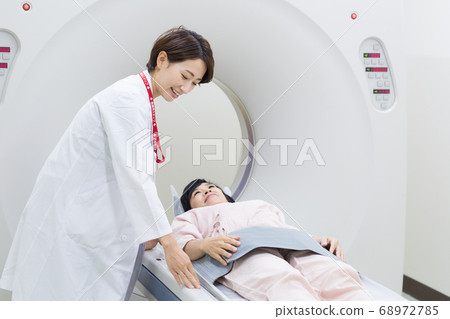 Woman undergoing CT examination of medical device Woman undergoing CT examination of medical device 68972785