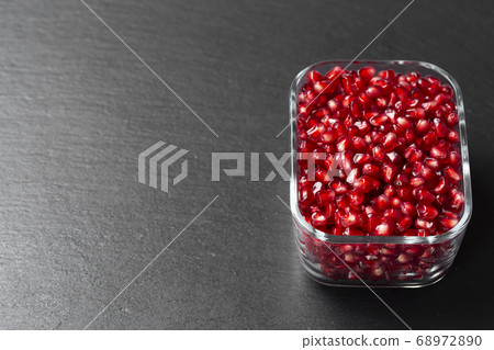 Peeled pomegranate in Minsk on a dark background. Peeled pomegranate in Minsk on a dark background. 68972890