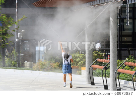 A person who is exposed to dry mist, a hot day, heat stroke prevention, heat stroke countermeasures, one girl 68973887